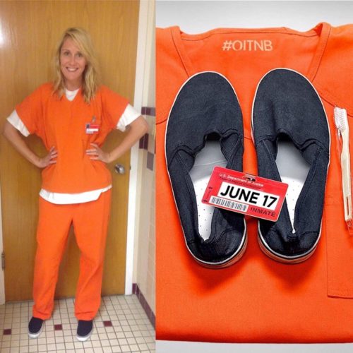 A woman in orange is standing next to an inmate uniform.
